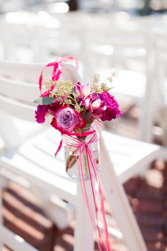 Mason jar with flowers and ribbons matching the bride's bouquet