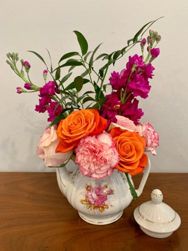Part of the tea pots project, this pot is a classic with its pink rose and gold trim design. No other way to match it than adding classic flowers - - roses and carnations with Italian ruscus green to complete this beauty.